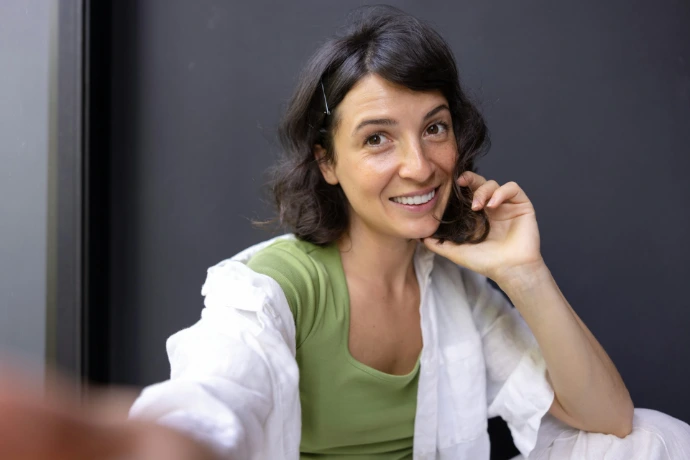 a woman sitting down talking on a cell phone